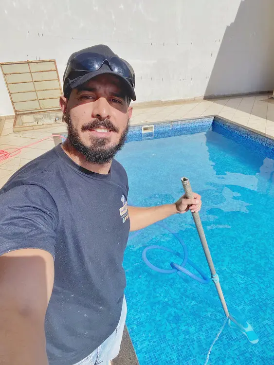 Profissional realizando limpeza de piscina